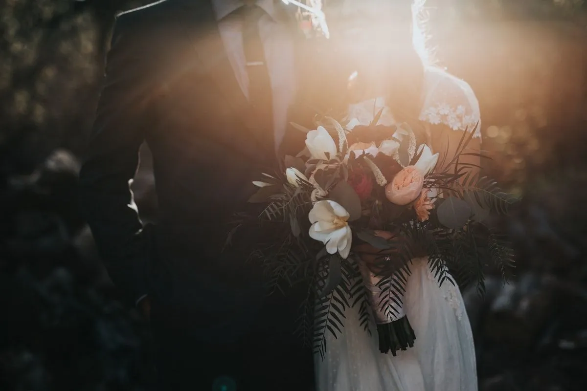 Bride holding a bouquet of roses and wildflowers