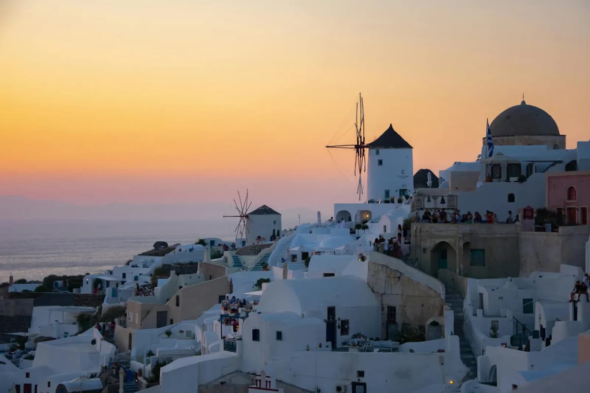 Split view comparing Oia and Fira villages in Santorini along the caldera edge