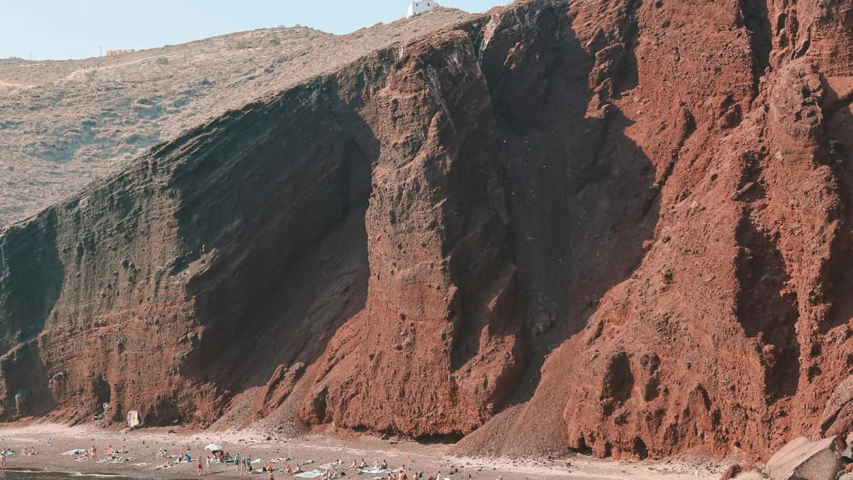 Red Beach Santorini with dramatic red volcanic cliffs meeting turquoise Aegean waters