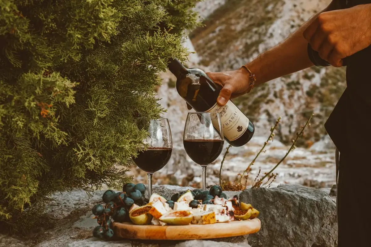 Wine glasses on a table at a Santorini vineyard with volcanic landscape views