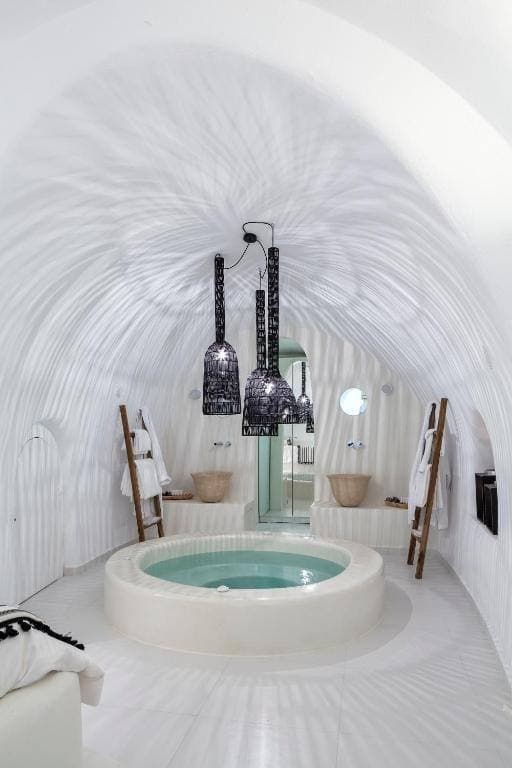 Honeymoon suite interior at Aroma Suites with cave-style architecture and caldera views in Santorini