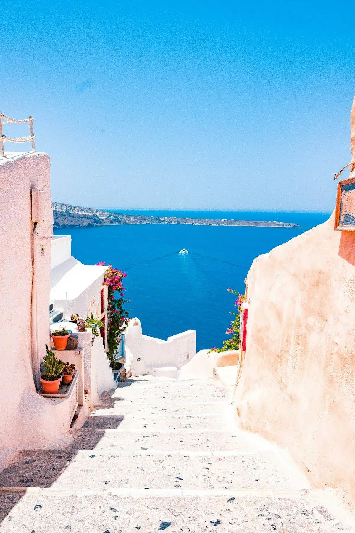 Narrow cobblestone street lined with local shops in a Santorini village