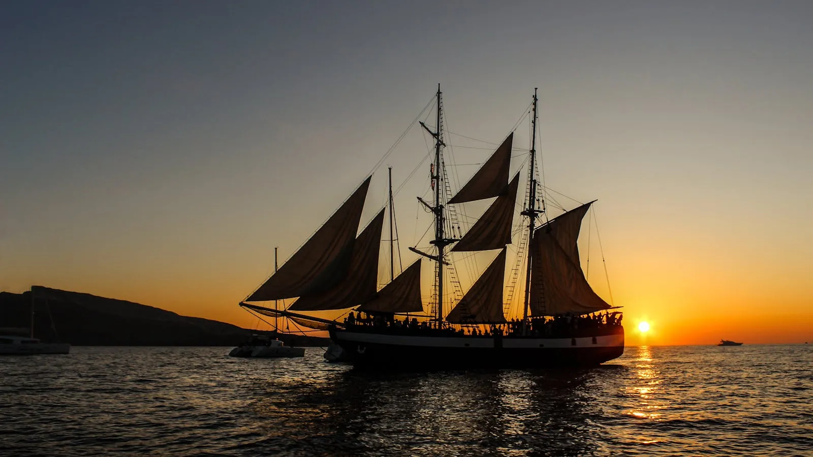 Traditional sailing ship silhouetted against the sunset on the Aegean