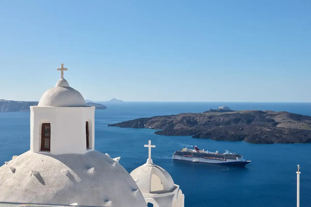 Breakfast on the caldera terrace at Aroma Suites with church dome and Aegean Sea view