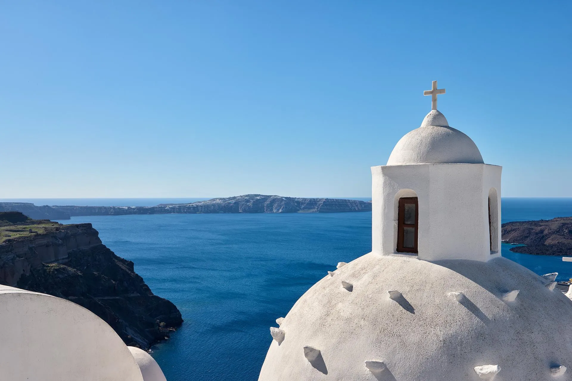 Whitewashed church dome overlooking the Santorini caldera from Fira